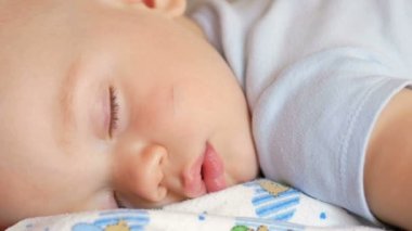 Güzel bebek komik poz bir yatakta uyuyor. Bebek bezi, yaklaşık bir yıl çocuk altında