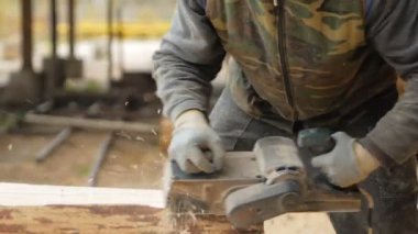 Ahşap bir bina projesi için bir parça planlama inşaat işçisi. İnşaat elektrik el uçak biler. Fabrika Binası, ağır çekim arka planı