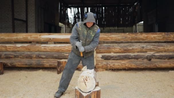 ビルダーは、斧で木造軸組を処理します。背景には木製の梁、スローモーションの家の未来の一部 — ストック動画