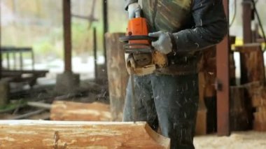 Adam kıvırcık kesme ahşap testere yapar. Günlük gelecekten Ahşap evin bir parçası olacak. Builder ve bir sürü talaş yüzünde koruyucu yüz maskesi.