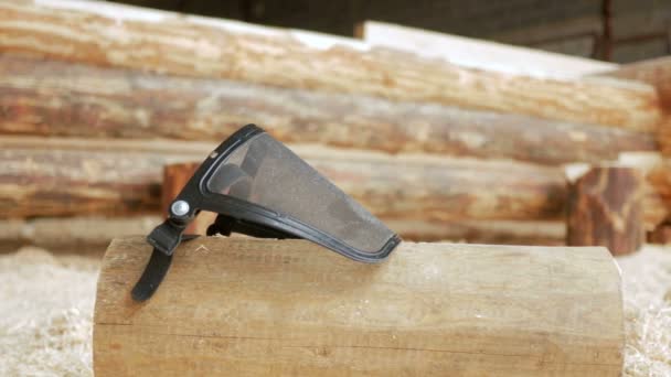 Protective face mask on coarse dust all over the face. Against the background of a wooden house and a lot of sawdust. The concept of safe operation — Stock Video