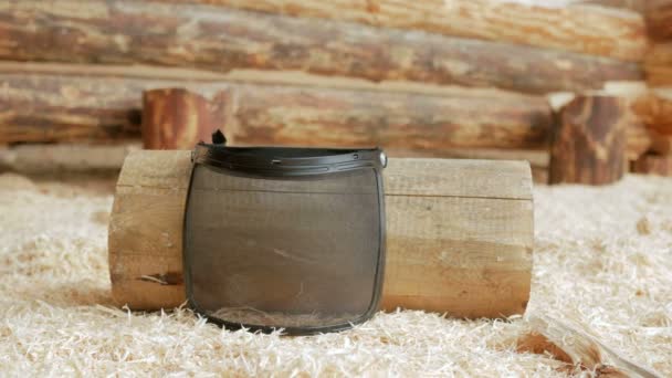 Mascarilla protectora en polvo grueso por toda la cara. Sobre el fondo de una casa de madera y un montón de serrín. El concepto de operación segura — Vídeo de stock