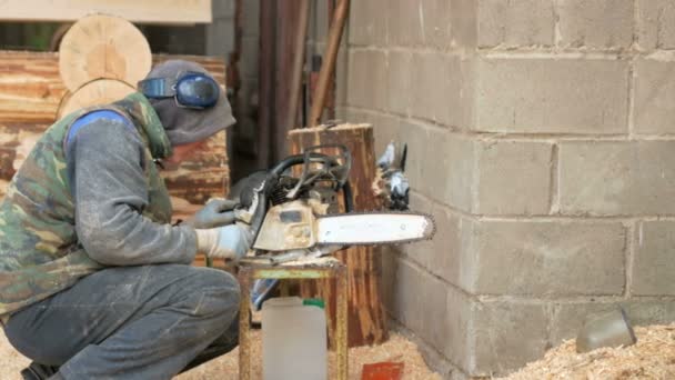 Le travail conduit la tronçonneuse de prévention. L'homme démonte et nettoie l'outil. déplacer la caméra — Video