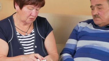 Yaşlı bir kadın kocasına evde kanepede bir hap ile bir bardak su verir. Zavallı adamın su kuyusu-varlık. Karısı kocası hakkında Bakımı
