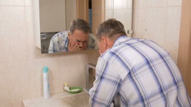 Man ouder je gezicht met zeep wassen in het bad. Hij rinses het gezicht met water na de ingreep. Het concept van zuiverheid — Stockvideo