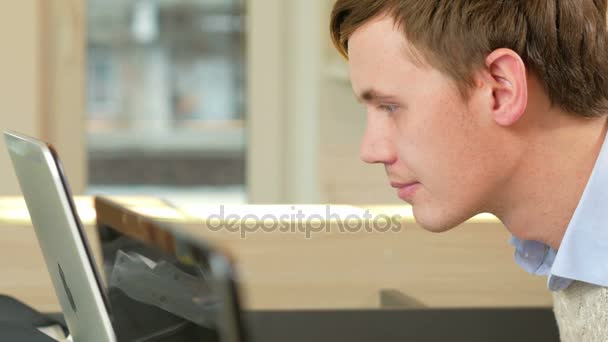 Мужчина смотрит на экран ноутбука в офисе. Концентрация перепроверяет цифры. Крупный план — стоковое видео