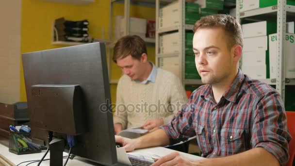 Mladý tým mužů pracujících na projektu v kanceláři u počítače. Zkontrolujte dokumenty o daních a vyplňte elektronický formulář. Týmové řešení problémů — Stock video