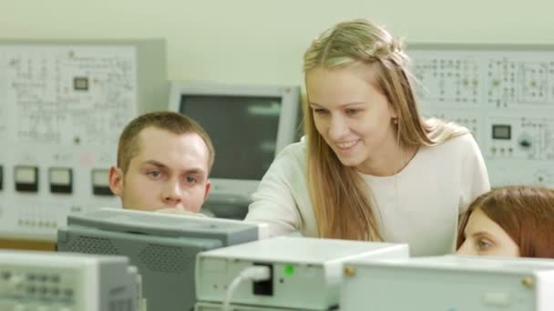 Mladý student inženýři týmová práce na univerzitě elektrické laboratoře. Poradenství a testování osciloskop voltmetr údaje na přístroji. Budoucí vědce — Stock video