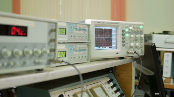 Elektromos jelek mérő berendezés van a fizikai laboratórium. Az eredménytábla világít WMI-adatok. Oszcilloszkóp és egy impulzus generátor működik együtt. — Stock videók