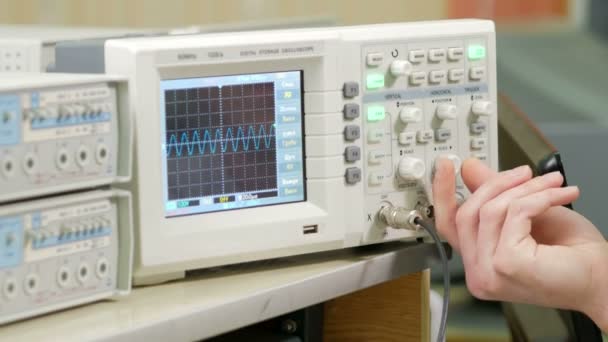 Bras d'ingénierie pour hommes ajuste l'oscilloscope pour un affichage correct du signal électrique. Petit oscilloscope industriel moderne — Video