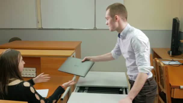 Mann liefert Laptops Klasse Universität in einer speziellen Box. zieht er heraus und legt die Frau auf den Tisch. Sie betreibt den Computer. Mobile Lade- und Speicherkarre. — Stockvideo