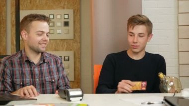 Bir adam kartı satın alma Ampüller terminal kullanarak Office için öder. O tutar ve bir kart ödeme sıvıştın çeker.