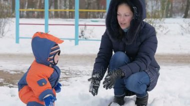 Anne ve yürümeye başlayan çocuk Kış Bahçesi yürüyüş ve kar ile eğleniyor. Kış keyfini bir aile. Kış yaşam tarzı kavramı.
