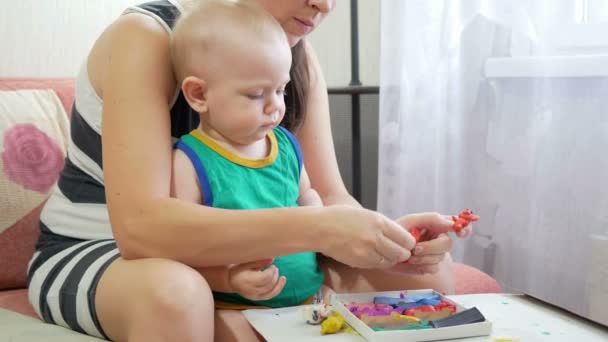 Mooie babyjongen beeldhouwt de klei met zijn moeder thuis. Samen plezier hebben en het maken van dierenfiguren. kind onderwijs concept — Stockvideo