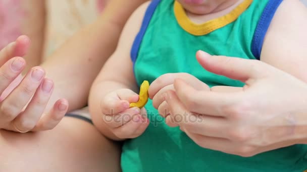 Bellissimo bambino scolpisce l'argilla con sua madre a casa. Insieme divertirsi e fare figurine animali. concetto di educazione dei bambini — Video Stock