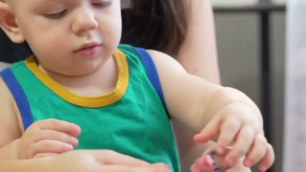 Beautiful baby boy sculpts the clay with his mother at home. Together having fun and making animal figurines. child education concept — Stock Video