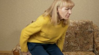 Kadınların yaş kanepeden geri içinde ev ağrı nedeniyle tırmanabilir miyim değil. O geri oturur ve Lomber masaj yapar