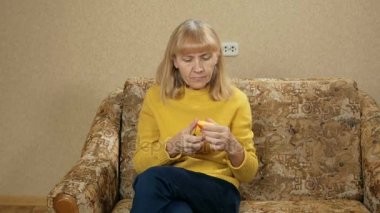 Kadınların yaş meyve evde kanepede yiyor. O kesikler Trabzon hurması bir parça kapalı ve tadını çıkarın. Sağlıklı gıda kavramı