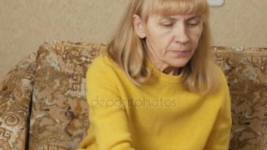 Bir kanepe ve içecekler su bir bardak hap içinde ev alarak hasta kadın kıdemli. Birkaç düzgün sıvı yapıyor. Yaşlılarda sağlık kavramı