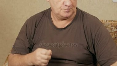 Bir kanepe ve içecekler su bir bardak hap içinde ev alarak hasta üst düzey kilolu adam. Birkaç düzgün sıvı hale getirir. Yaşlılarda sağlık kavramı