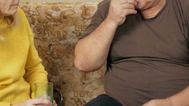 Üst düzey bir çift evde hapları. Erkek kilolu bir hap alır, kadın bir bardak su alır. Yaşlılıkta bakım kavramı