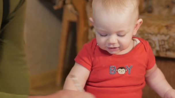 Atractivo bebé sentado en la olla y dibujando con los marcadores de su abuelo en papel. El chico orinando y jugando con la casa de la familia. Niño 1 año . — Vídeos de Stock