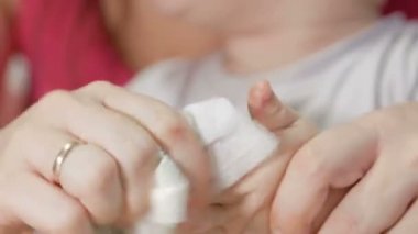 Anne pamuk yastık ile boyama sonra bebek eller yıkar. Parmakları uzun bir süre için temizlenir. Yakın çekim.