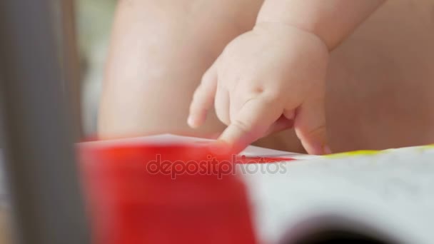 Χέρι το παιδί αντλεί τα χρώματα σε ένα χαρτί με τη μητέρα του. Το δάχτυλο είναι βουτηγμένα στο χρώμα και οδηγεί για το χρωματισμό. Γκρο πλαν. — Αρχείο Βίντεο
