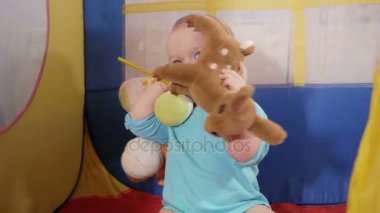 Sarılma erkek geyik ve aslan doldurulmuş. Çekici bebek evde çocuk renkli çadırda oynarken.