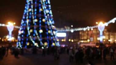 Yeni yıl bulanık arka plan Şehir Meydanı. Noel ağacının etrafında akşam festivaller kentsel sakinleri