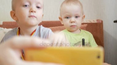 Güzel kardeş çocuklar video onun dedesi ile konuşuyor. Onlar ve seyir telefon radyo ile oynamak
