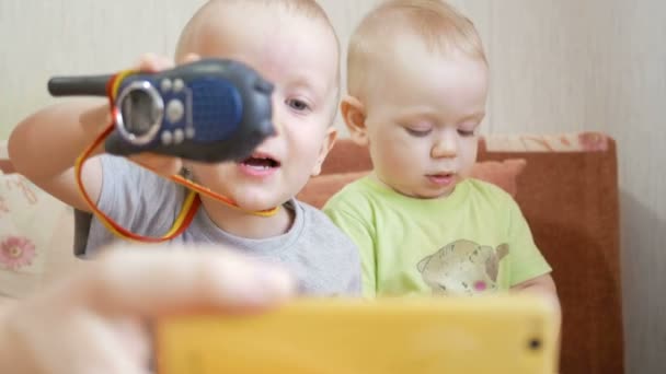 Beautiful brothers kids talking on video with his grandparents. They play with the radio and looking at phone — Stock Video