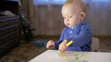 Dedesi onun torunu çocukla işaretleri kağıt üzerinde çizer. Çocuk dikkatle bakar ve yardım. Gülümseyen ve sürpriz. Öğretim çocuklar evde kavramının