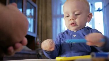 Dedesi onun torunu çocukla işaretleri kağıt üzerinde çizer. Çocuk dikkatle bakar ve yardım. Gülümseyen ve sürpriz. Öğretim çocuklar evde kavramının
