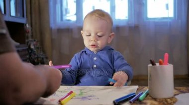 Dedesi onun torunu çocukla işaretleri kağıt üzerinde çizer. Çocuk dikkatle bakar ve yardım. Gülümseyen ve sürpriz. Öğretim çocuklar evde kavramının