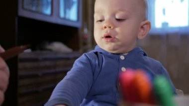 Dedesi onun torunu çocukla işaretleri kağıt üzerinde çizer. Çocuk dikkatle bakar ve yardım. Gülümseyen ve sürpriz. Öğretim çocuklar evde kavramının