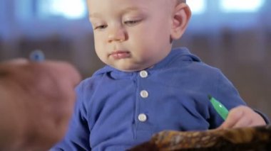 Dedesi onun torunu çocukla işaretleri kağıt üzerinde çizer. Çocuk dikkatle bakar ve yardım. Gülümseyen ve sürpriz. Öğretim çocuklar evde kavramının