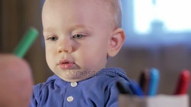 Dedesi onun torunu çocukla işaretleri kağıt üzerinde çizer. Çocuk dikkatle bakar ve yardım. Gülümseyen ve sürpriz. Öğretim çocuklar evde kavramının