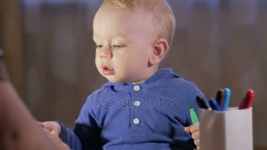 Dedesi onun torunu çocukla işaretleri kağıt üzerinde çizer. Çocuk dikkatle bakar ve yardım. Gülümseyen ve sürpriz. Öğretim çocuklar evde kavramının