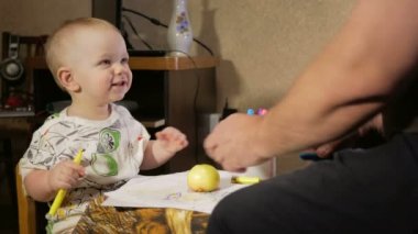 Dedesi onun torunu çocukla işaretleri kağıt üzerinde çizer. Çocuk dikkatle bakar ve yardım. Gülümseyen ve sürpriz. Öğretim çocuklar evde kavramının