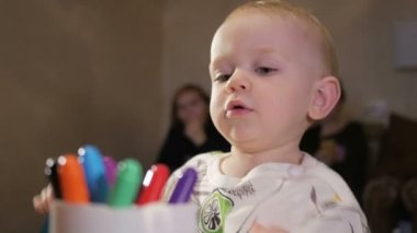 Dedesi onun torunu çocukla işaretleri kağıt üzerinde çizer. Çocuk dikkatle bakar ve yardım. Gülümseyen ve sürpriz. Öğretim çocuklar evde kavramının