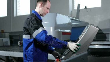 Mekanik teknisyeni makine Cnc Delme programlama. Bir adam verileri dikkatlice Denetim Masası'na girer. Metal bir arka planda işlenir