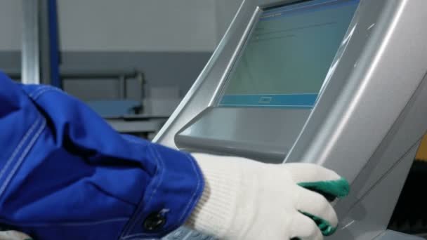 Técnico mecánico programando perforando la máquina CNC. Un hombre ingresa los datos cuidadosamente para controlar el panel. El metal se procesa sobre un fondo — Vídeos de Stock