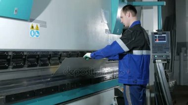 Cnc Hidrolik Pres frene sac ile çalışan adam. O parçayı koyar ve açılı büyük bir makine içine kıvıran