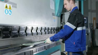 Cnc Hidrolik Pres frene sac ile çalışan adam. O parçayı koyar ve açılı büyük bir makine içine kıvıran