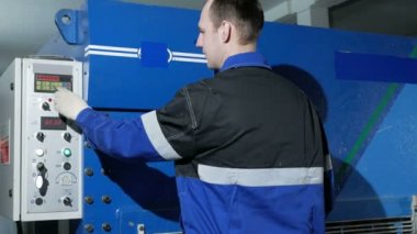 Adam kesme sac metal makine operasyon büyük hidrolik giyotin biçme makineleri üzerinde ayarlar. Ütü presler düğmesine ve parçaların üretim başlar