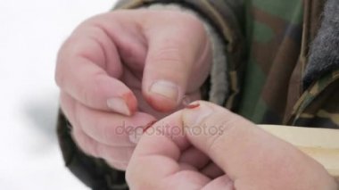 Adam kış balıkçılık devreye girer. O balık bekliyor ve kanca yem atıyor. Sıcak koruyucu kılığına girmiş
