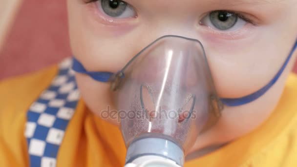 The kid himself holding a mask from an inhaler and breathes the medicine at home. Treats inflammation of the airways via nebulizer. Preventing asthma and cough. — Stock Video