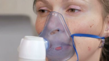 Astım bir maske evde tutan genç kadın. Nebulizatör ile solunum yolları iltihabı davranır. Astım ve öksürük önlenmesi