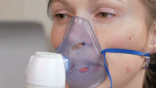 Une jeune femme tenant un masque d'un inhalateur à la maison. Traite l'inflammation des voies respiratoires via un nébuliseur. Prévenir l'asthme et la toux — Video